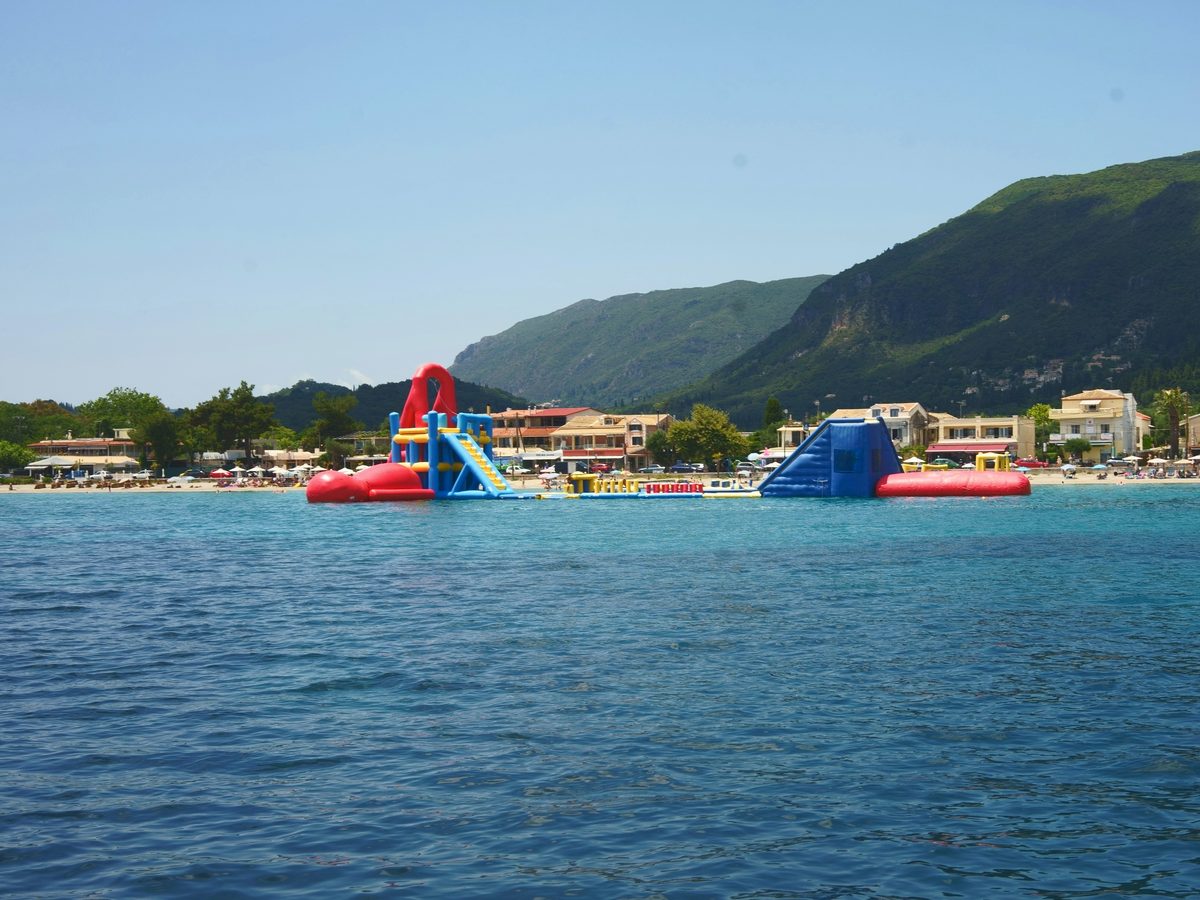 An inflatable water park moored off a resort beach
