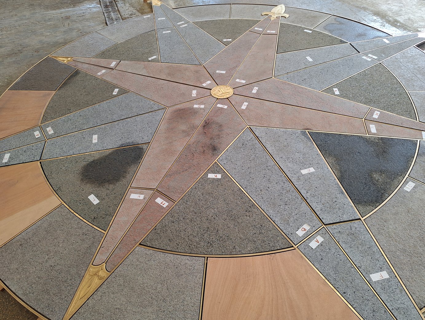 A large compass rose of coloured stone and brass strips set into the paving of the castle bridge