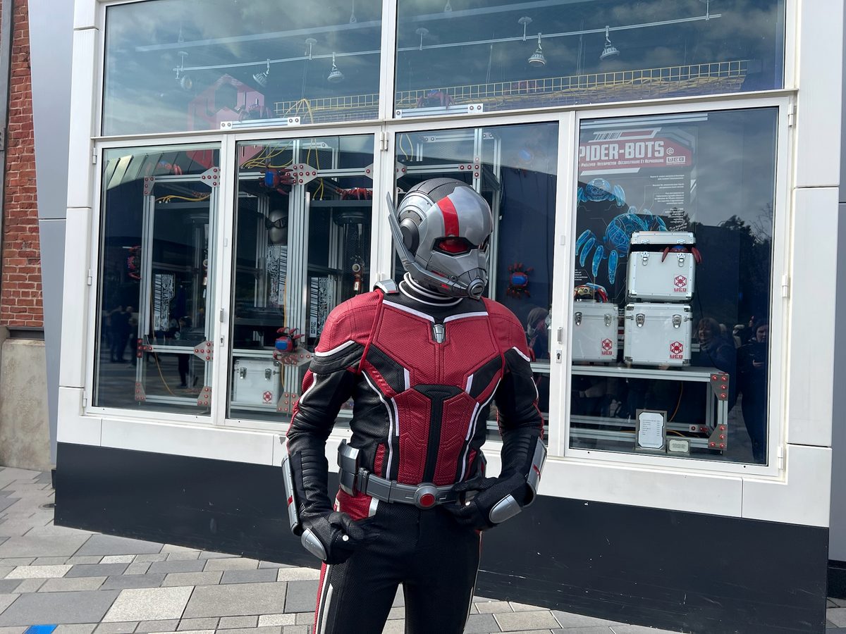 An Ant-Man character in costume meeting guests in Avengers Campus