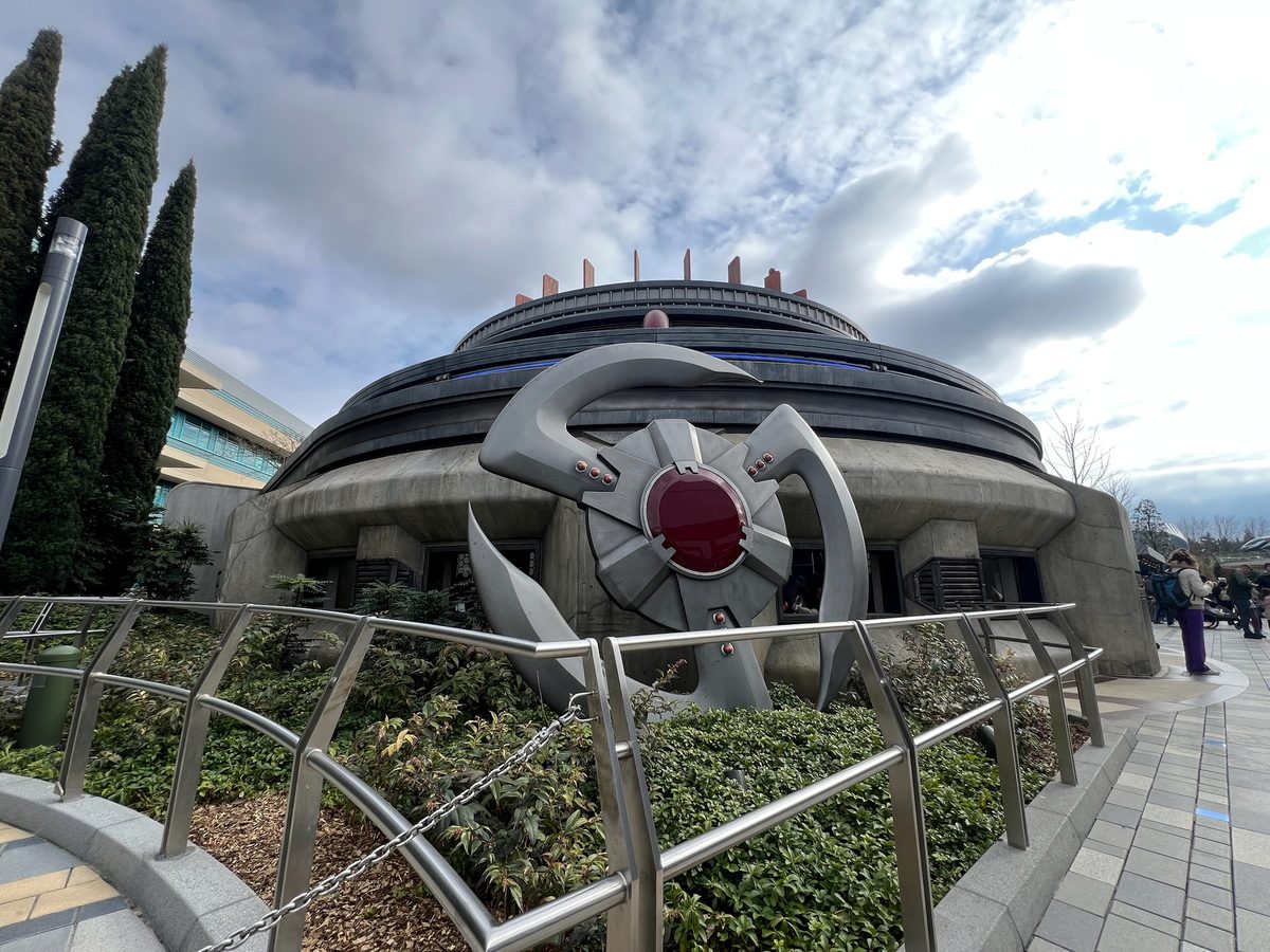 The circular concrete building of Avengers Assemble: Flight Force, with a silver Avengers emblem at its entrance