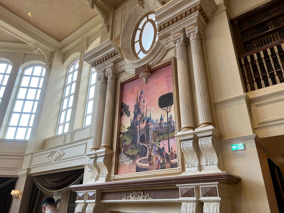 A framed painting of Sleeping Beauty Castle with princesses at a fountain, set into a panelled wall inside the Disneyland Hotel