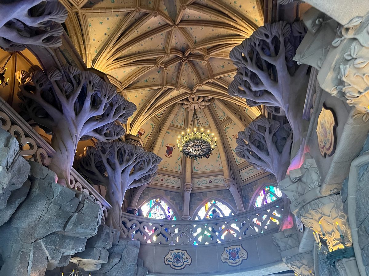 The vaulted ceiling, sculpted trees and stained-glass windows of the gallery upstairs in the castle