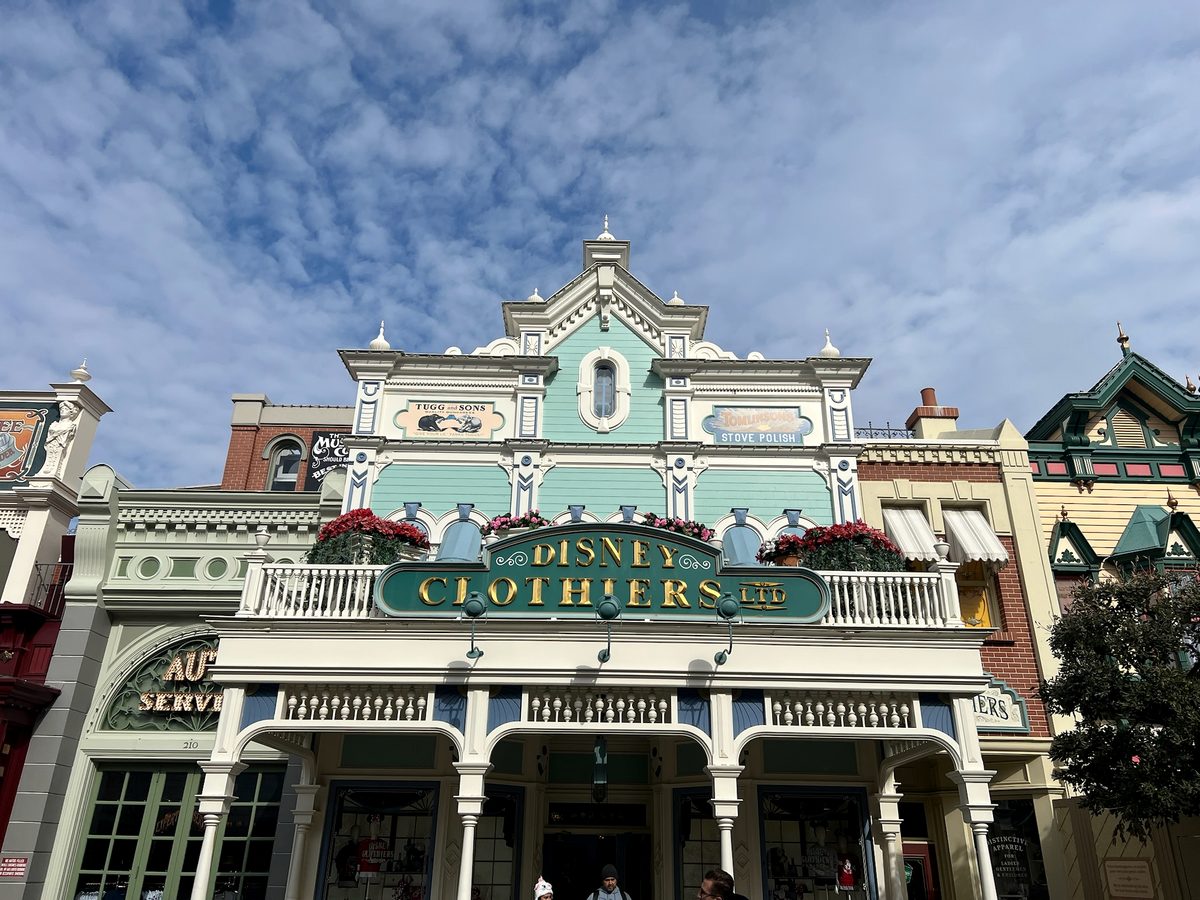 The pale-green Disney Clothiers facade with its balcony and gold lettering on Main Street