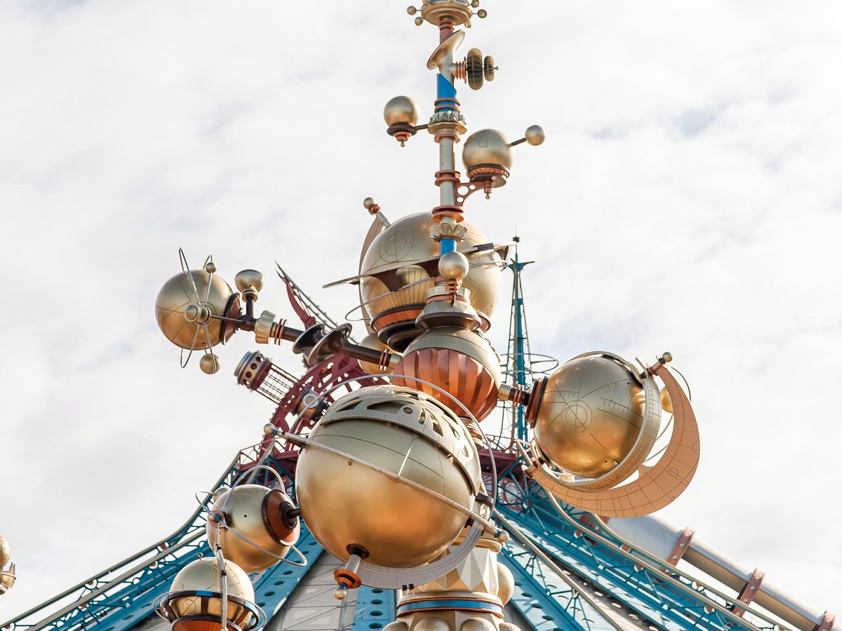 The stacked golden planets of Orbitron above the ride in Discoveryland
