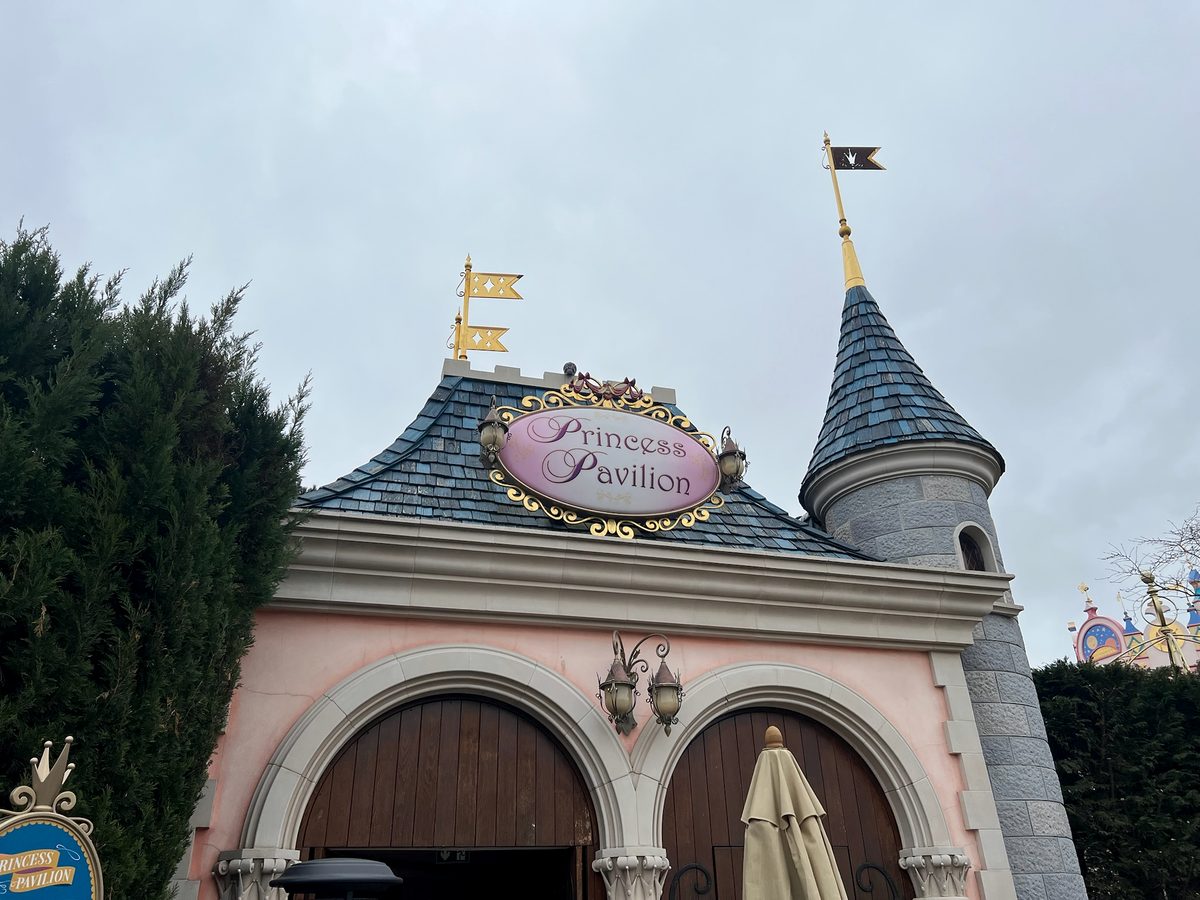 The pink walls, turret and oval sign of the Princess Pavilion in Fantasyland