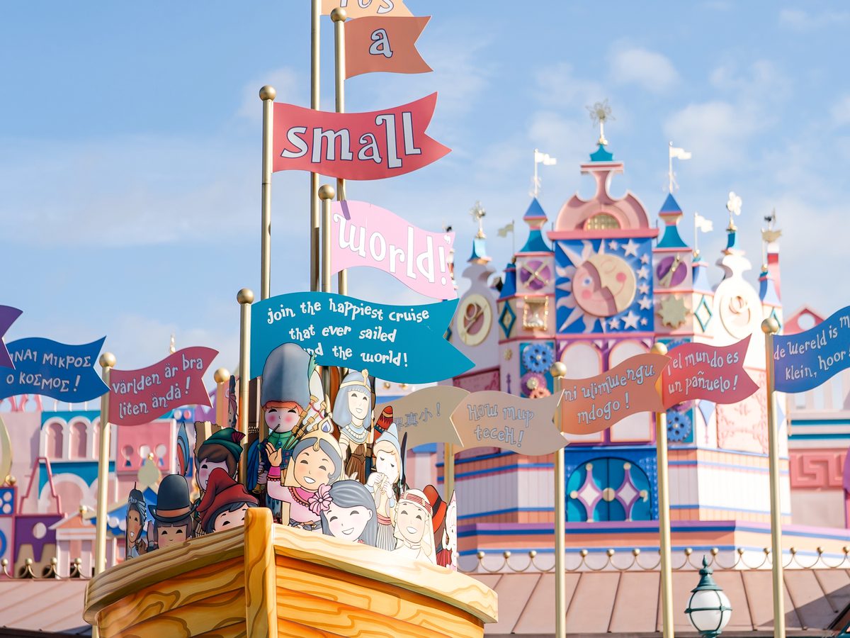 The boat sculpture and multilingual welcome flags outside "it's a small world"