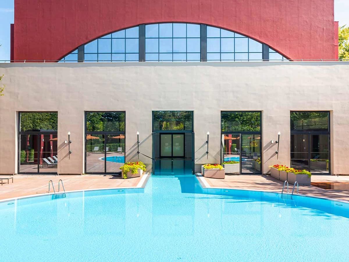 The outdoor pool outside the red art-deco wall of the Metro Pool building on a sunny day