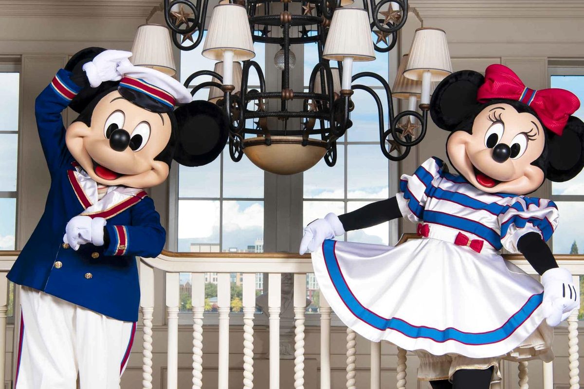 Captain Mickey in a navy jacket and white trousers saluting, beside Minnie in a blue-and-white striped nautical dress with a red bow, in the hotel