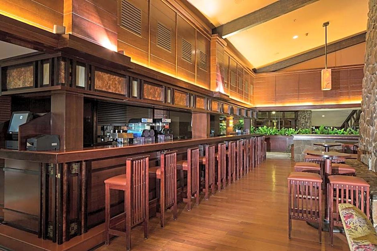 The Redwood Bar at Disney Sequoia Lodge, a long timber counter with craftsman-style stools lit low beneath the beams, a stone pillar to one side
