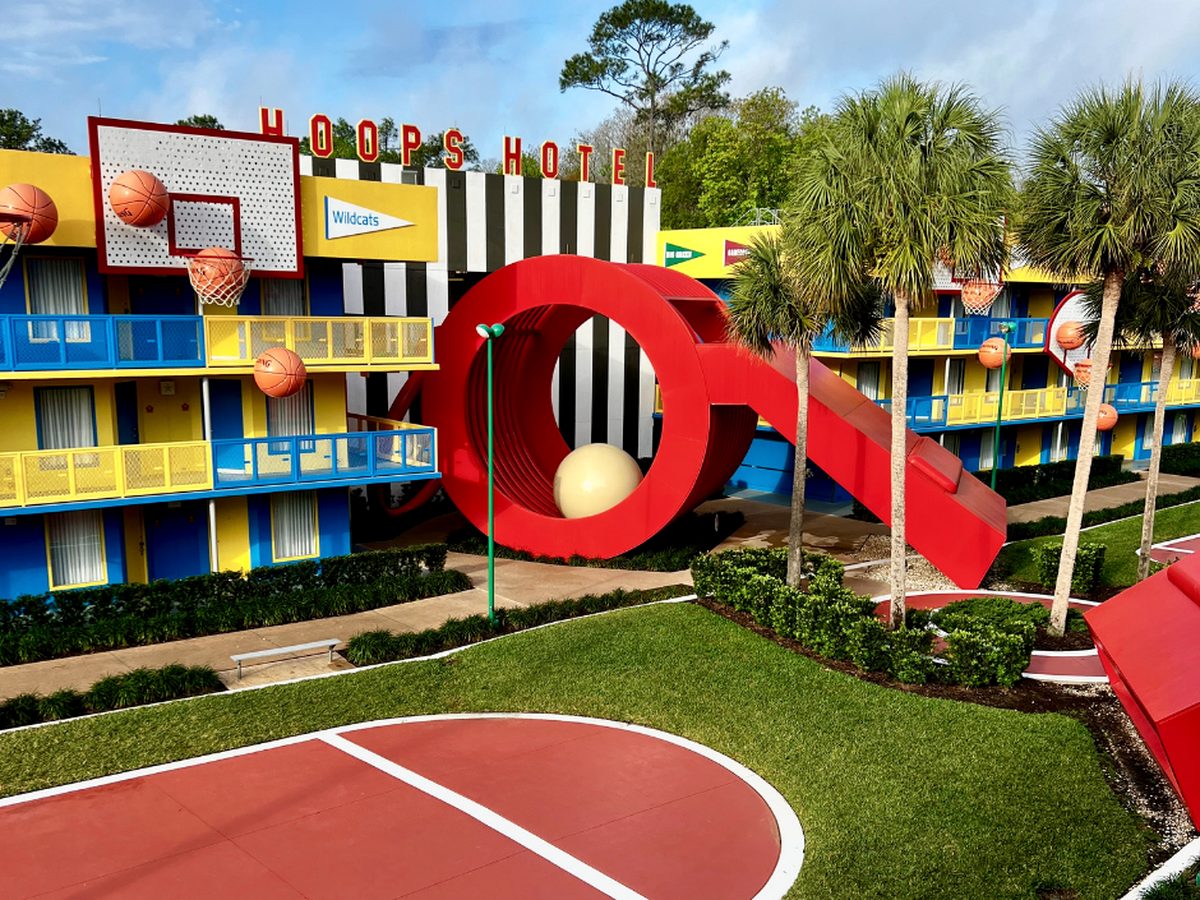 The Hoops Hotel courtyard at Disney All-Star Sports, a giant red whistle and basketball hoops over a court laid out between the room blocks