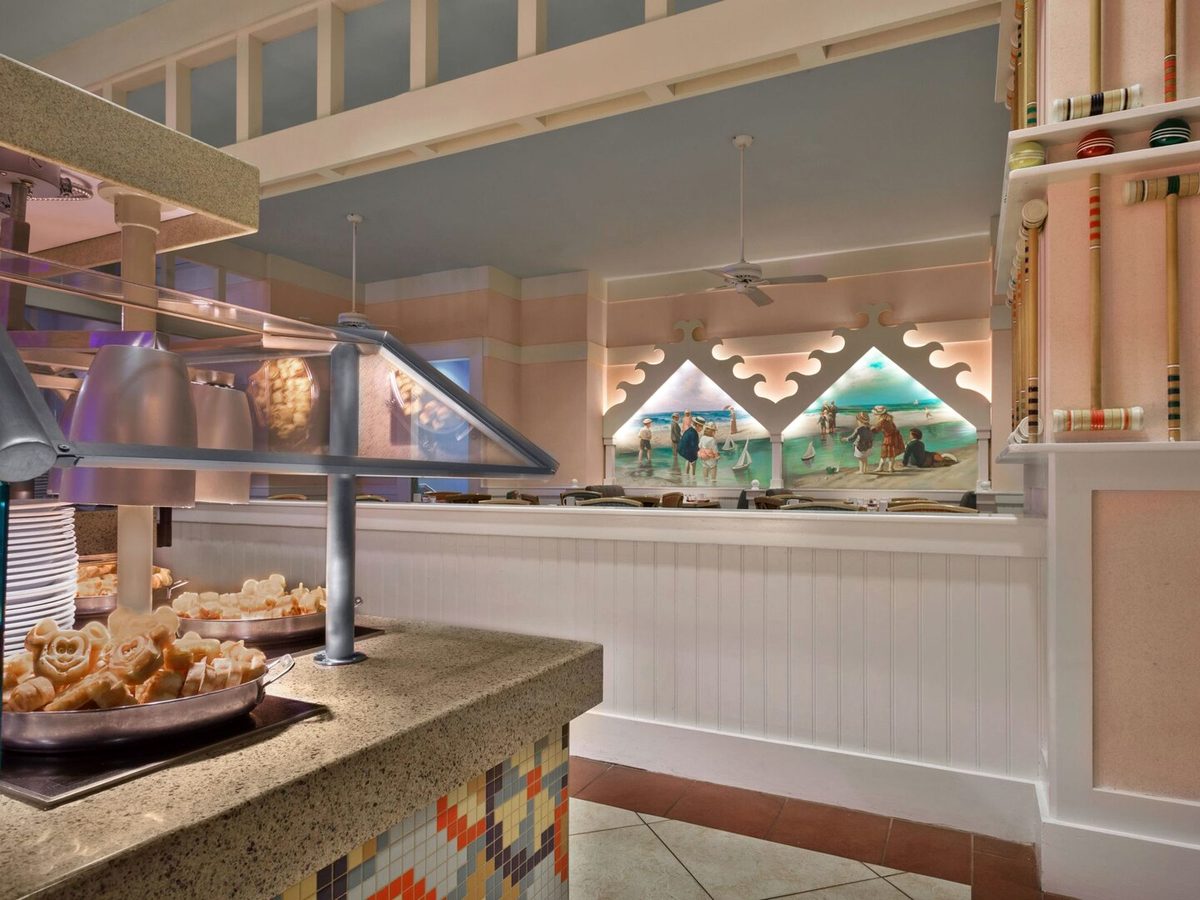 The buffet counter at Cape May Cafe, lined with plates and pastries beneath seaside murals and croquet mallets on the wall