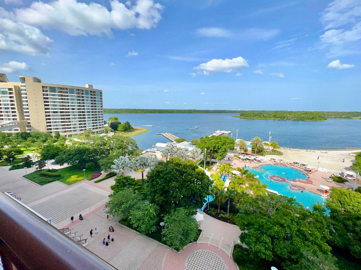 Looking down from Disney's Contemporary Resort over the pools, trees and white-sand beach on Bay Lake, with the curved Bay Lake Tower on the left