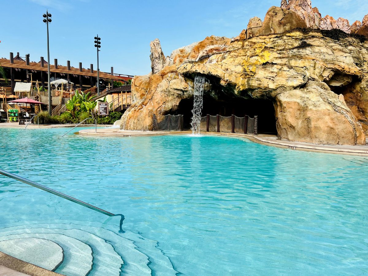 The Lava Pool at Disney's Polynesian Village Resort, turquoise water in front of the volcano rockwork with a waterfall pouring over its grotto