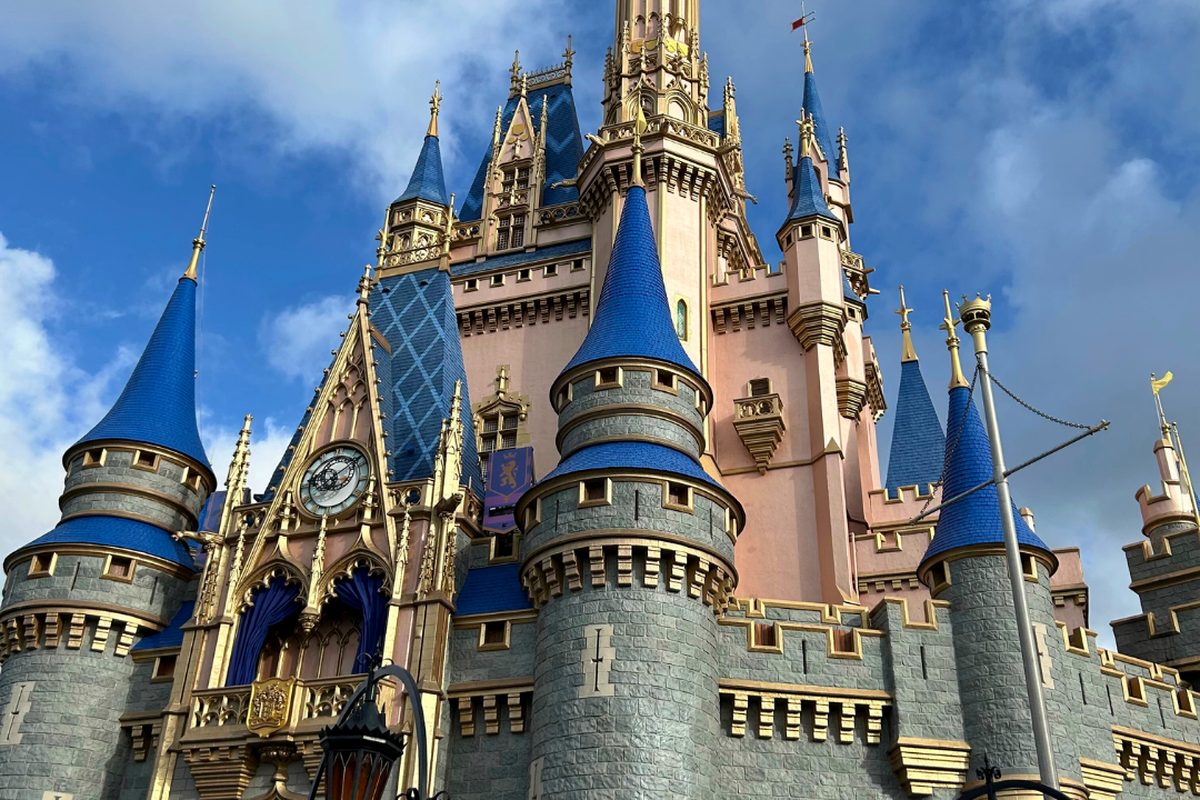 Cinderella Castle at Magic Kingdom, pink walls and blue-grey turrets against a bright sky