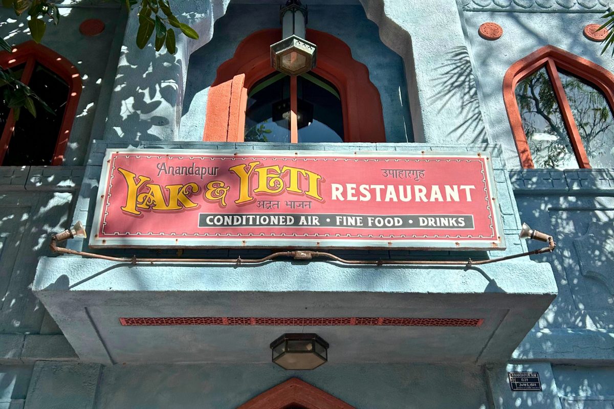 The Yak & Yeti Restaurant sign above the entrance of the blue Nepalese-themed building in the Asia area of Animal Kingdom