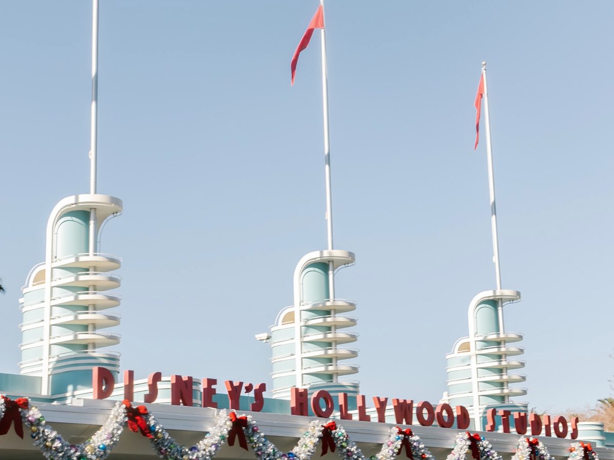 The art-deco towers and Disney's Hollywood Studios lettering over the park entrance, Christmas garlands strung below