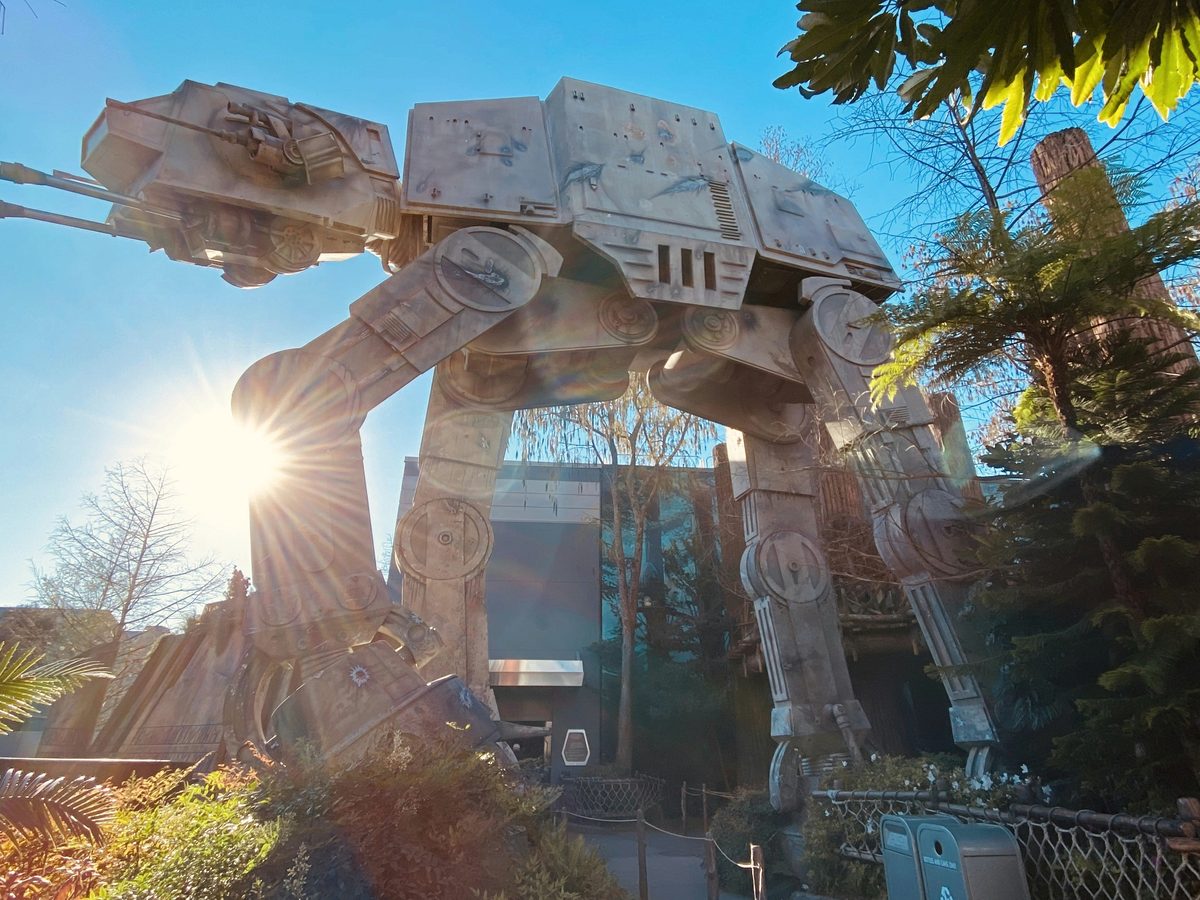 The full-size AT-AT walker standing over the Star Tours entrance at Echo Lake, against a blue sky
