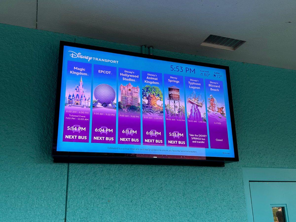 The Disney Transport screen at a resort bus stop, listing the next bus to each park, Disney Springs and the water parks with the current time and temperature