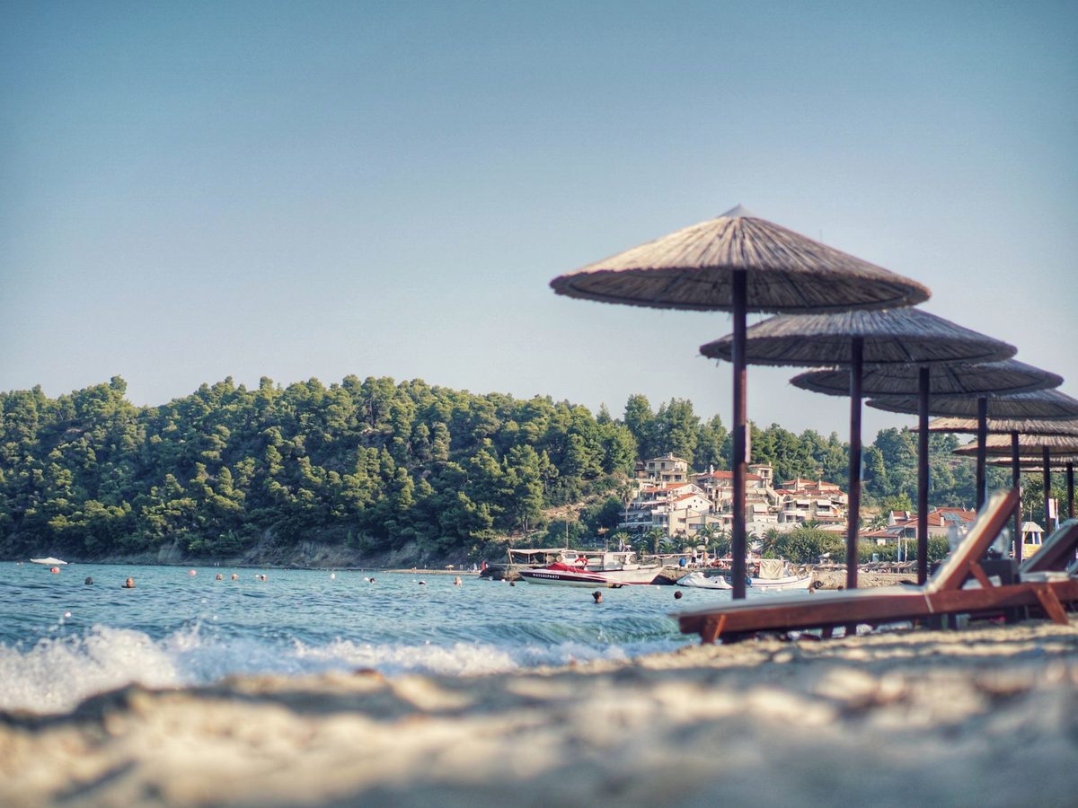 Straw parasols over clear, calm water