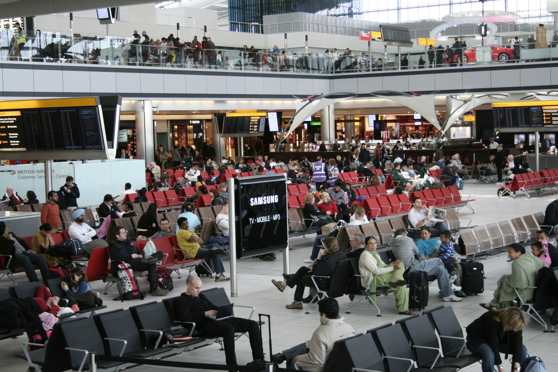 Passengers sitting in a waiting area at Heathrow Airport