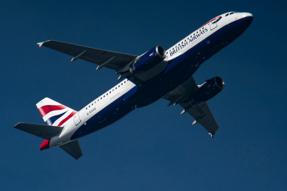 A British Airways aircraft climbing against a blue sky