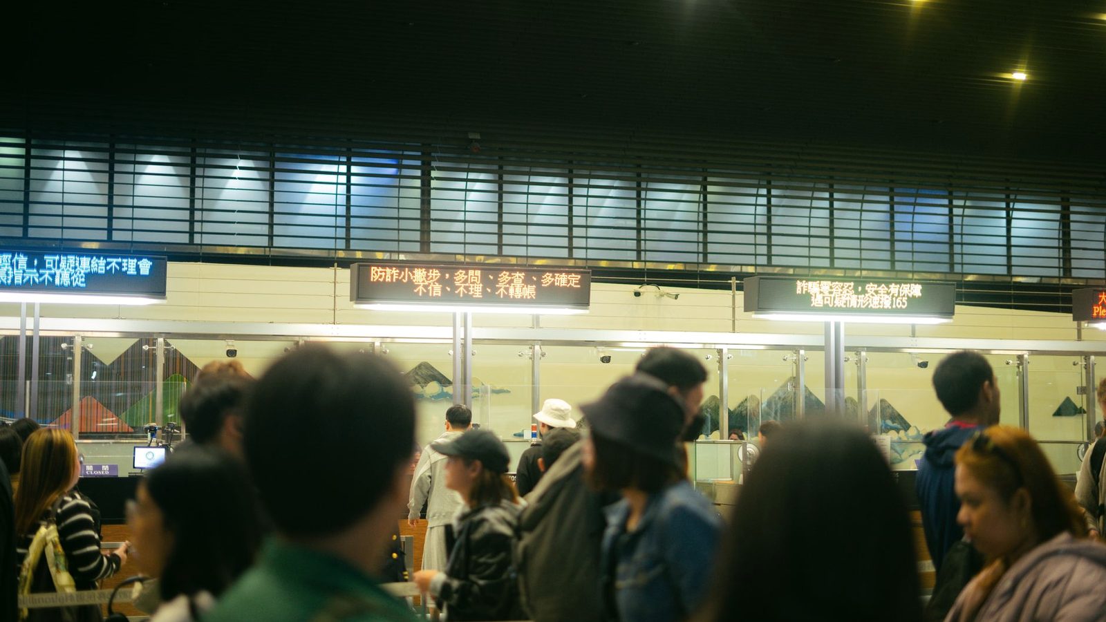 Travellers queueing at passport control in an airport