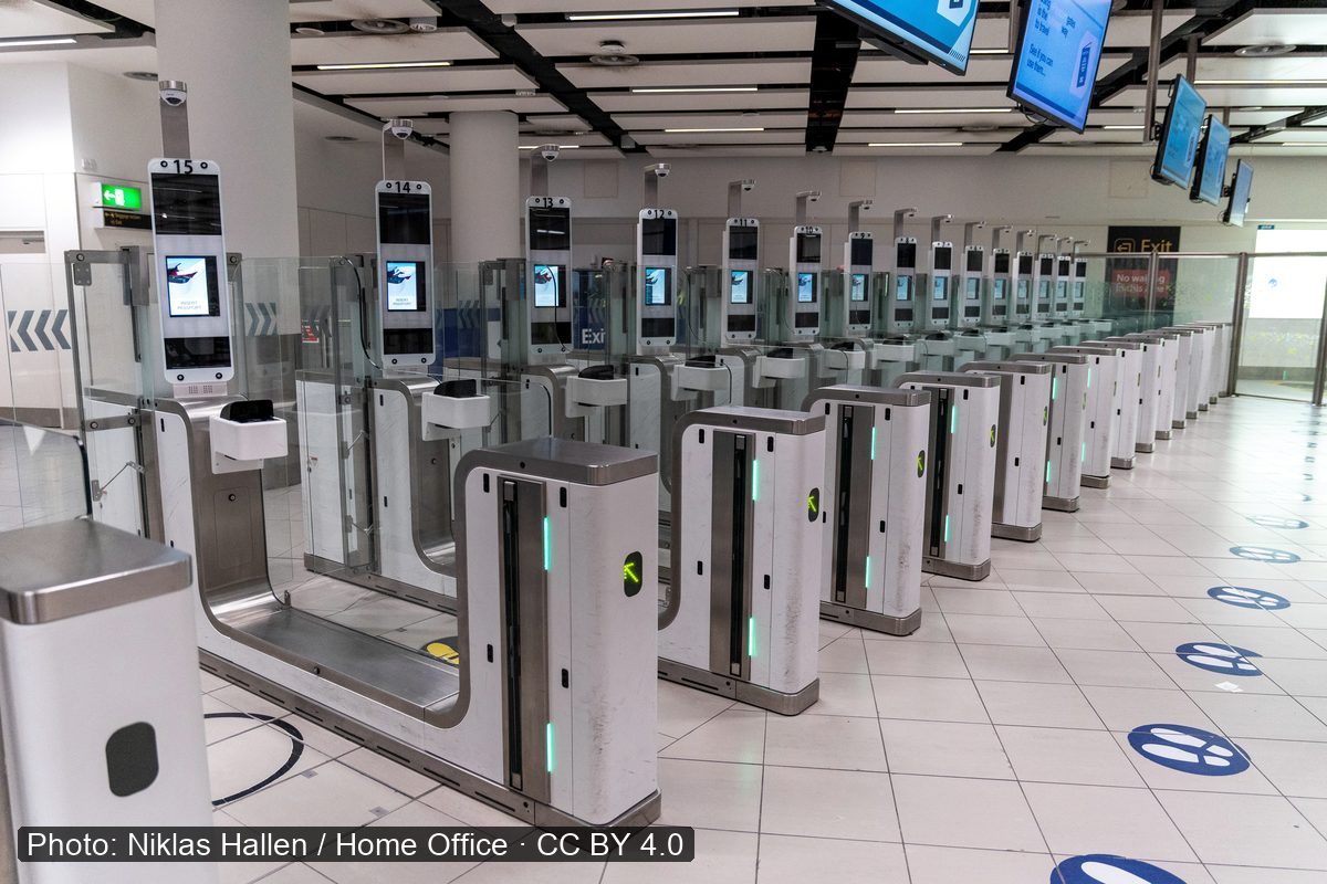 Rows of automated passport gates with overhead monitors.