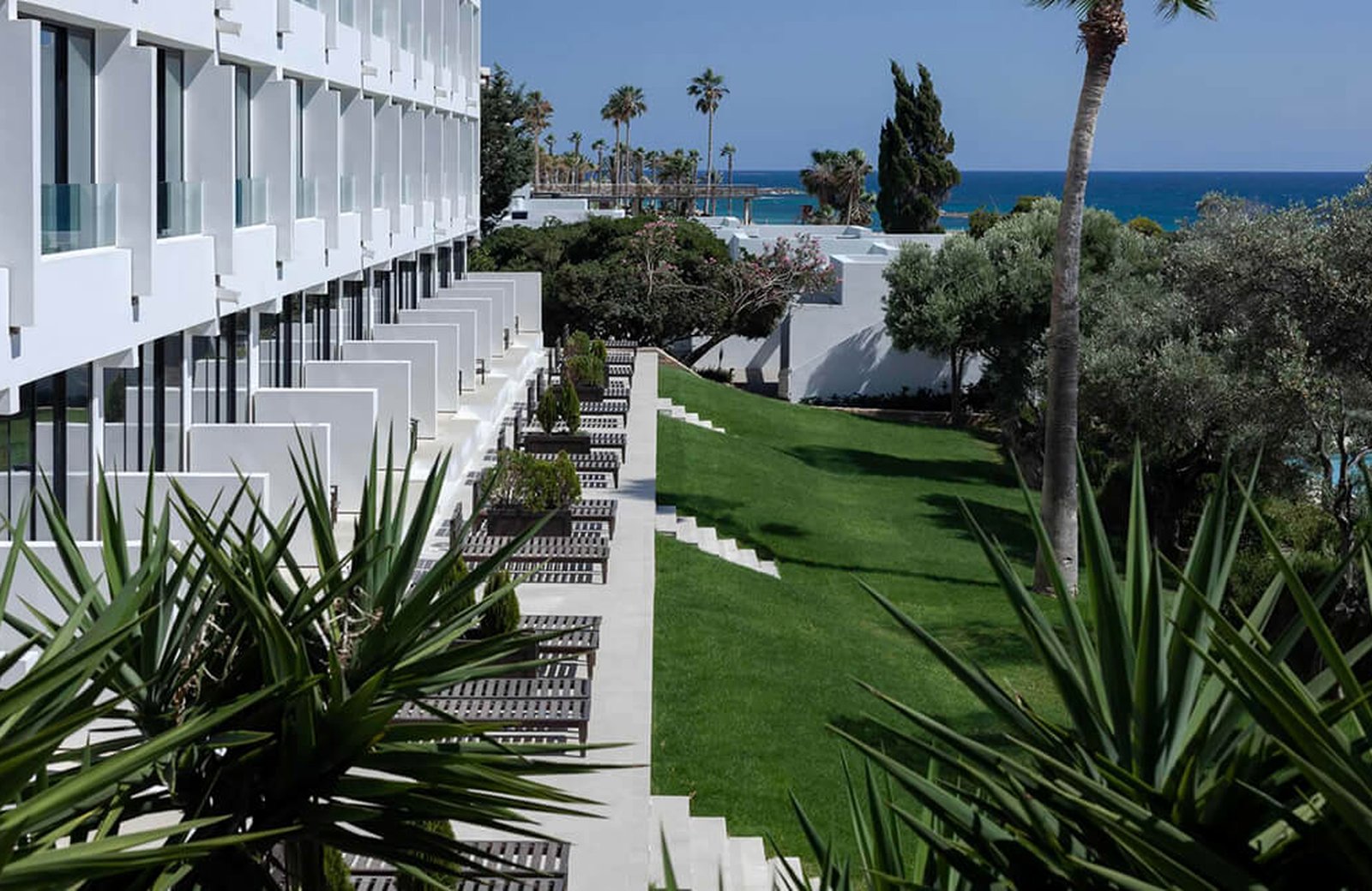 Almyra Hotel on the Paphos seafront, its gardens and pools between the building and the Mediterranean.