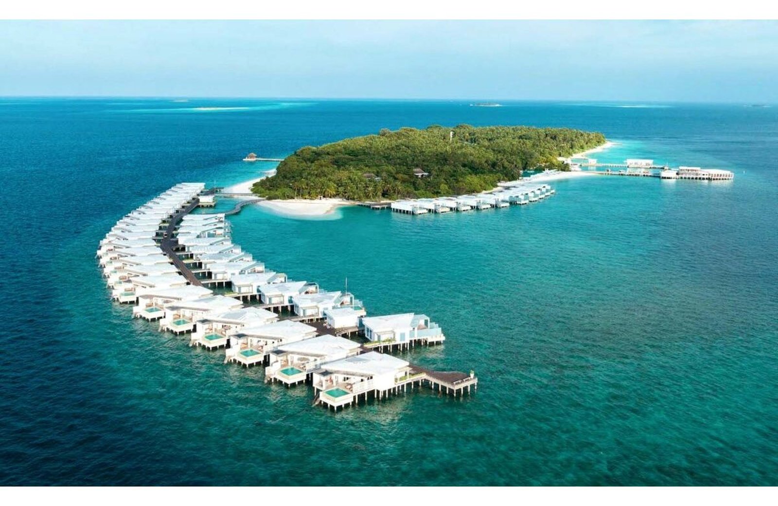 Amilla Maldives: overwater and beach villas around a green island ringed by a turquoise lagoon in Baa Atoll.