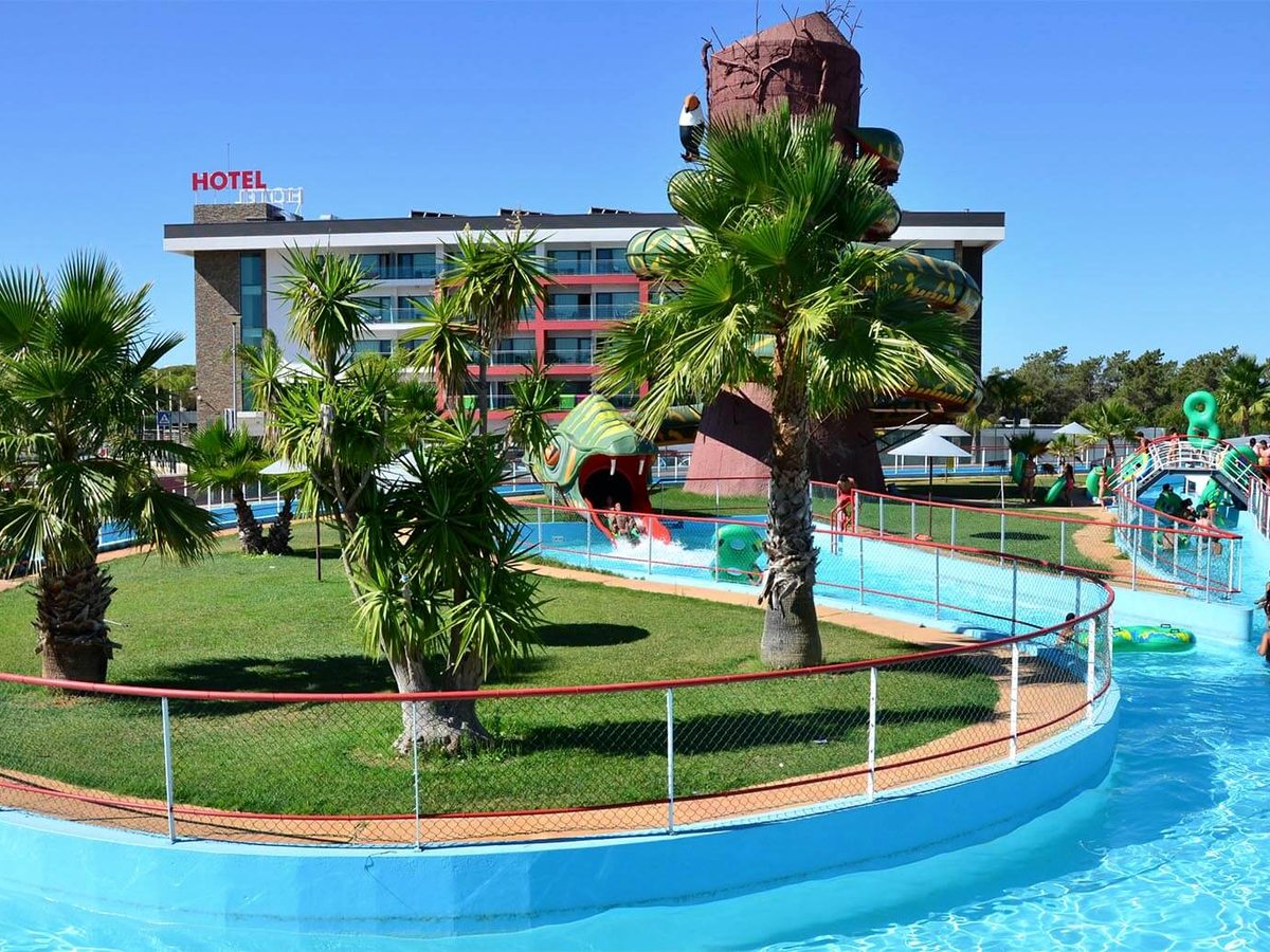 A curving lazy-river channel with small water slides and palm-planted islands beside the hotel.