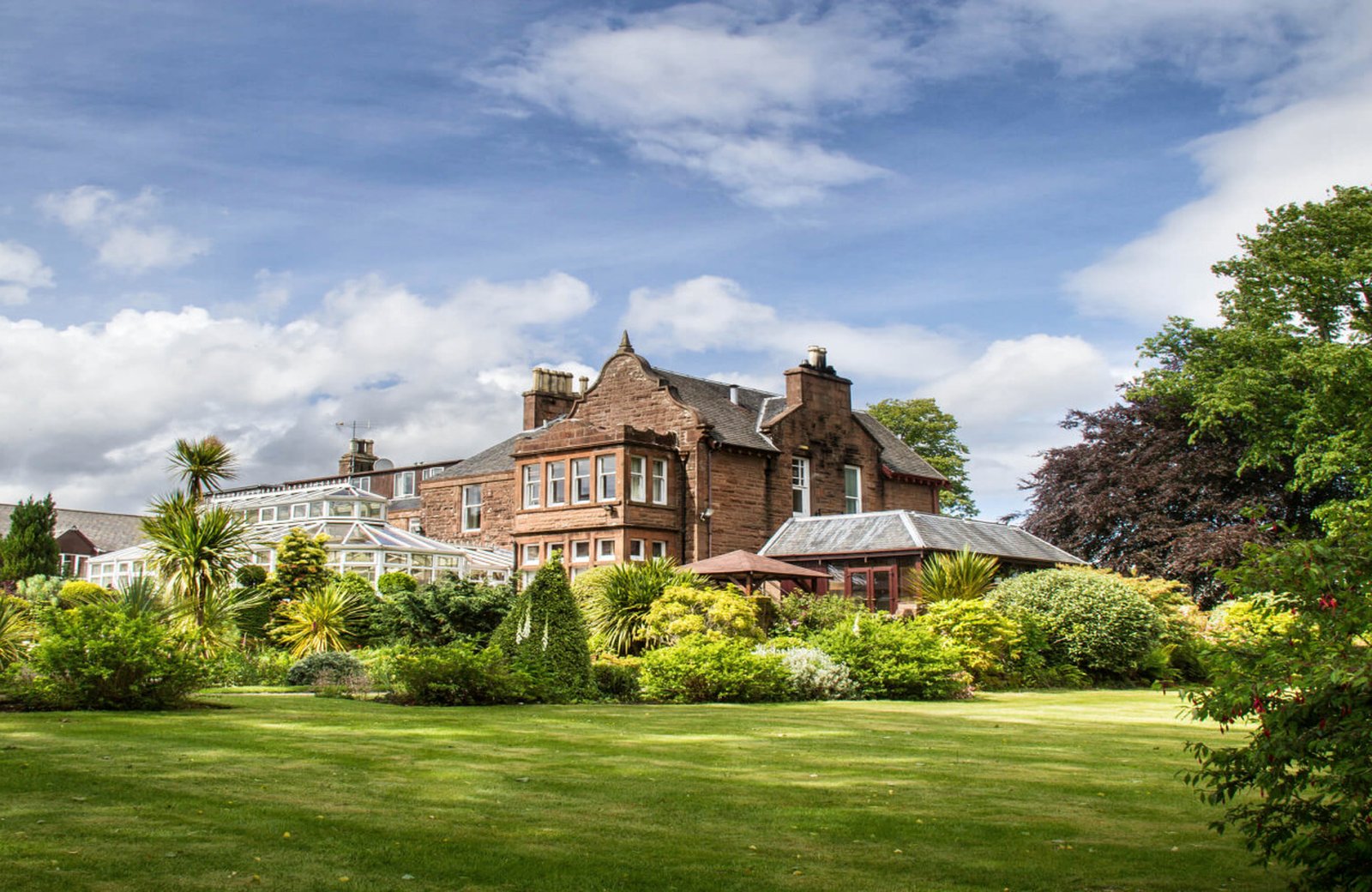 Auchrannie Resort set in a glen just outside Brodick on the Isle of Arran, with its hotel buildings among wooded grounds.