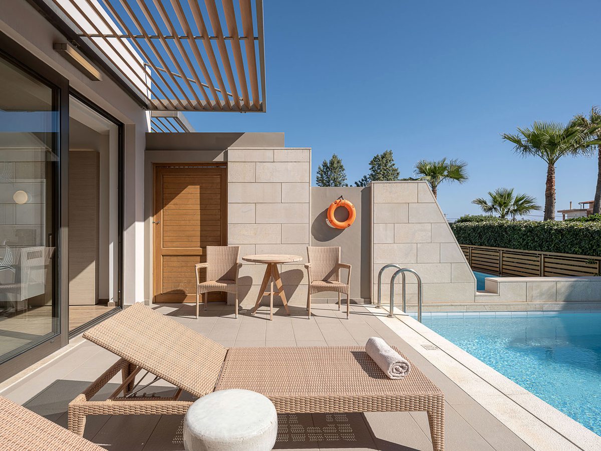 A suite terrace with a private plunge pool, sun loungers and a pergola on a walled patio.