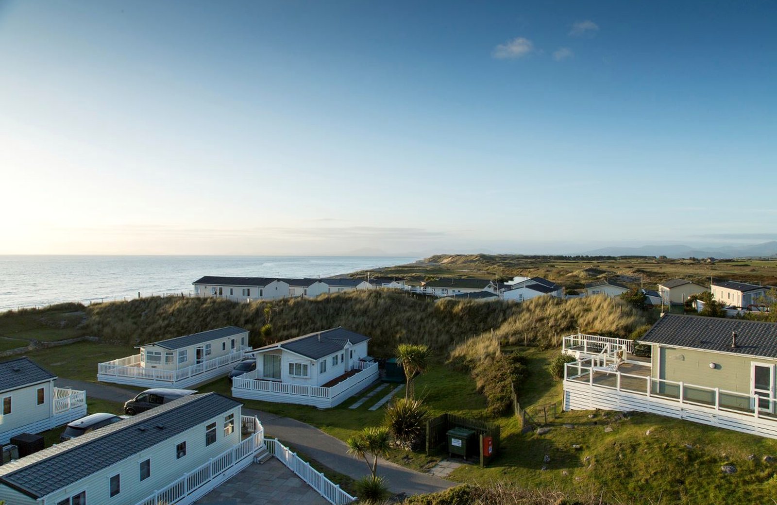 Barmouth Bay Holiday Park, with caravans and lodges set below the mountains of Eryri near the beach at Talybont in North Wales.