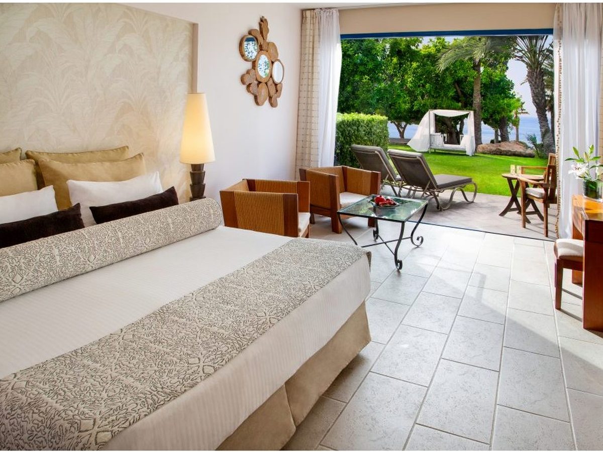 Ground-floor suite with a double bed and armchairs and glass doors to a private garden terrace.