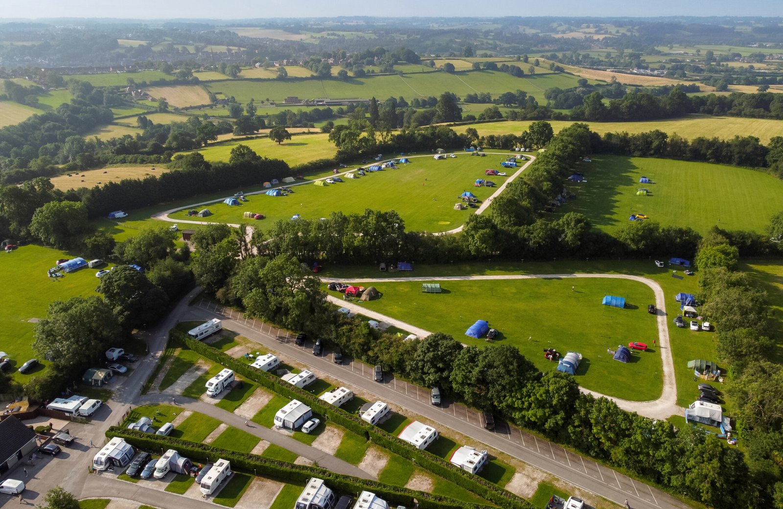 Callow Top Holiday Park on elevated ground near Ashbourne in the Derbyshire Peak District, with pitches and countryside beyond.