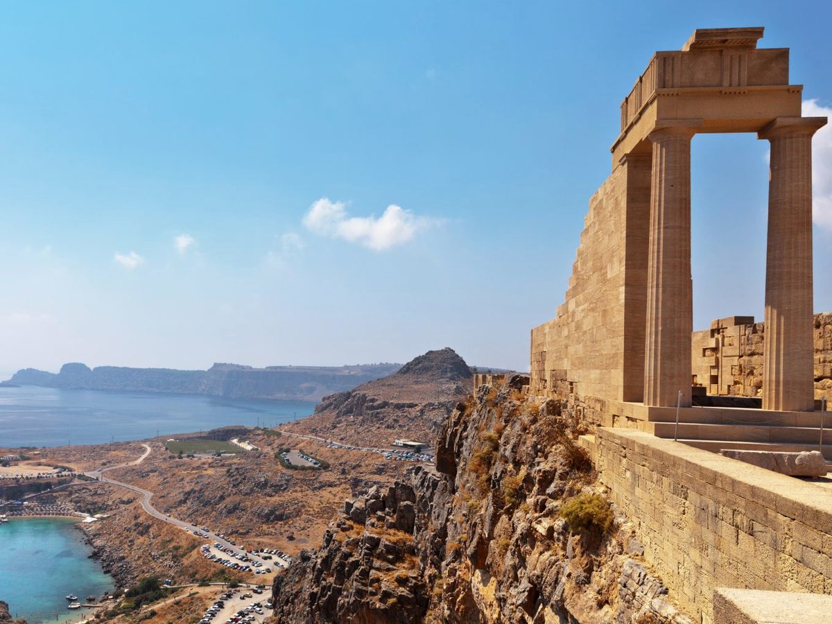 Ancient temple ruins on the clifftop Acropolis of Lindos with the coastline and sea far below