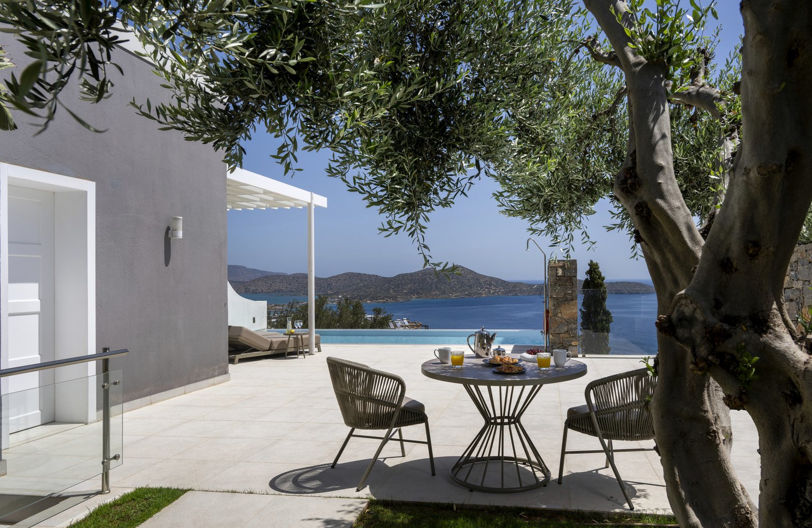 Elounda Gulf Villas on its hillside above the Gulf of Mirabello, with terraced villas and private pools looking out to sea.