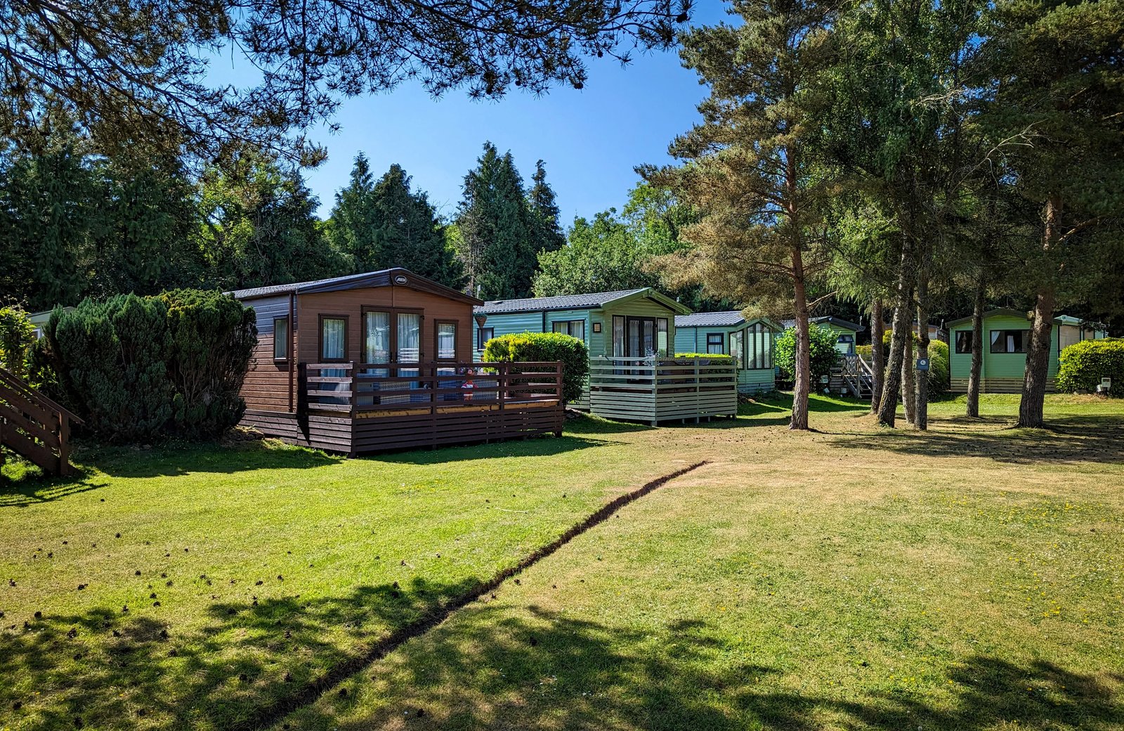 Fell End Holiday Park in its wooded Cumbrian setting near Milnthorpe, with holiday lodges and caravans among grass and trees.