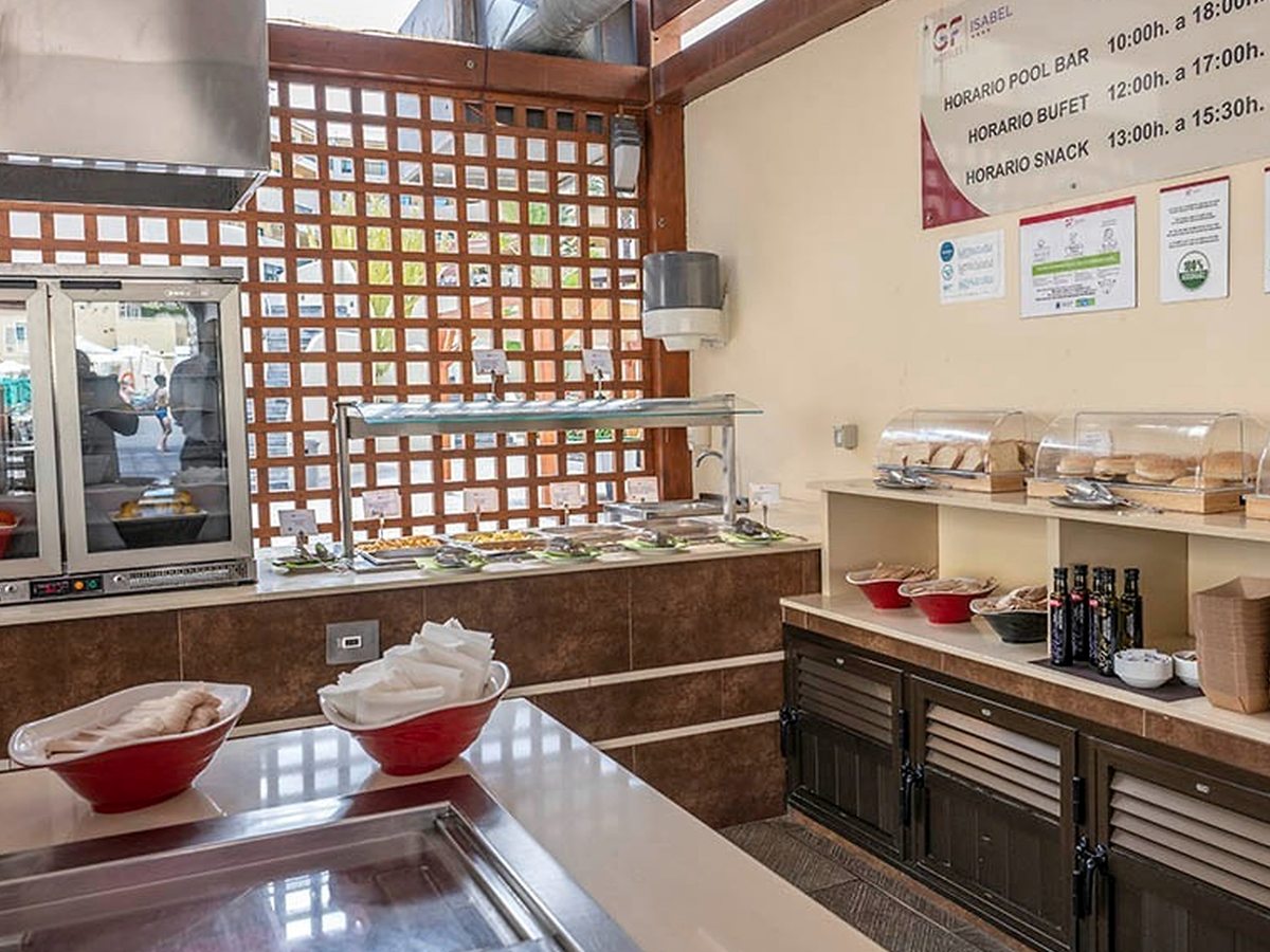 The Pool Bar's servery, with a hot buffet counter, bread and rolls under domed covers, and a sign listing the pool bar, buffet and snack hours.