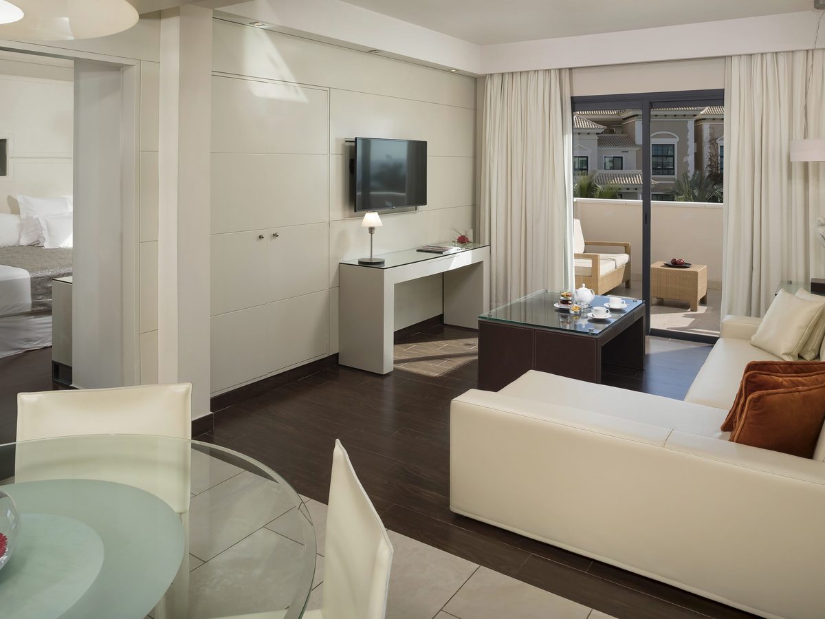 A family suite with a living area in the foreground and a twin bedroom visible through to one side.