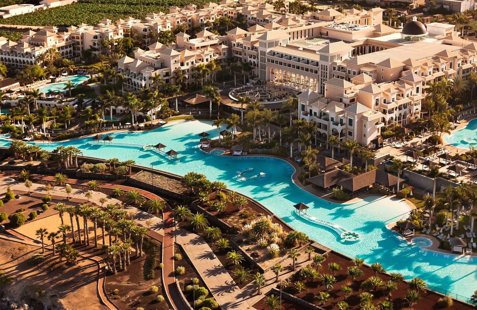 An aerial view of Gran Meliá Palacio de Isora, its tiered white buildings and large turquoise pool complex above the Atlantic at Alcalá, south-west Tenerife.