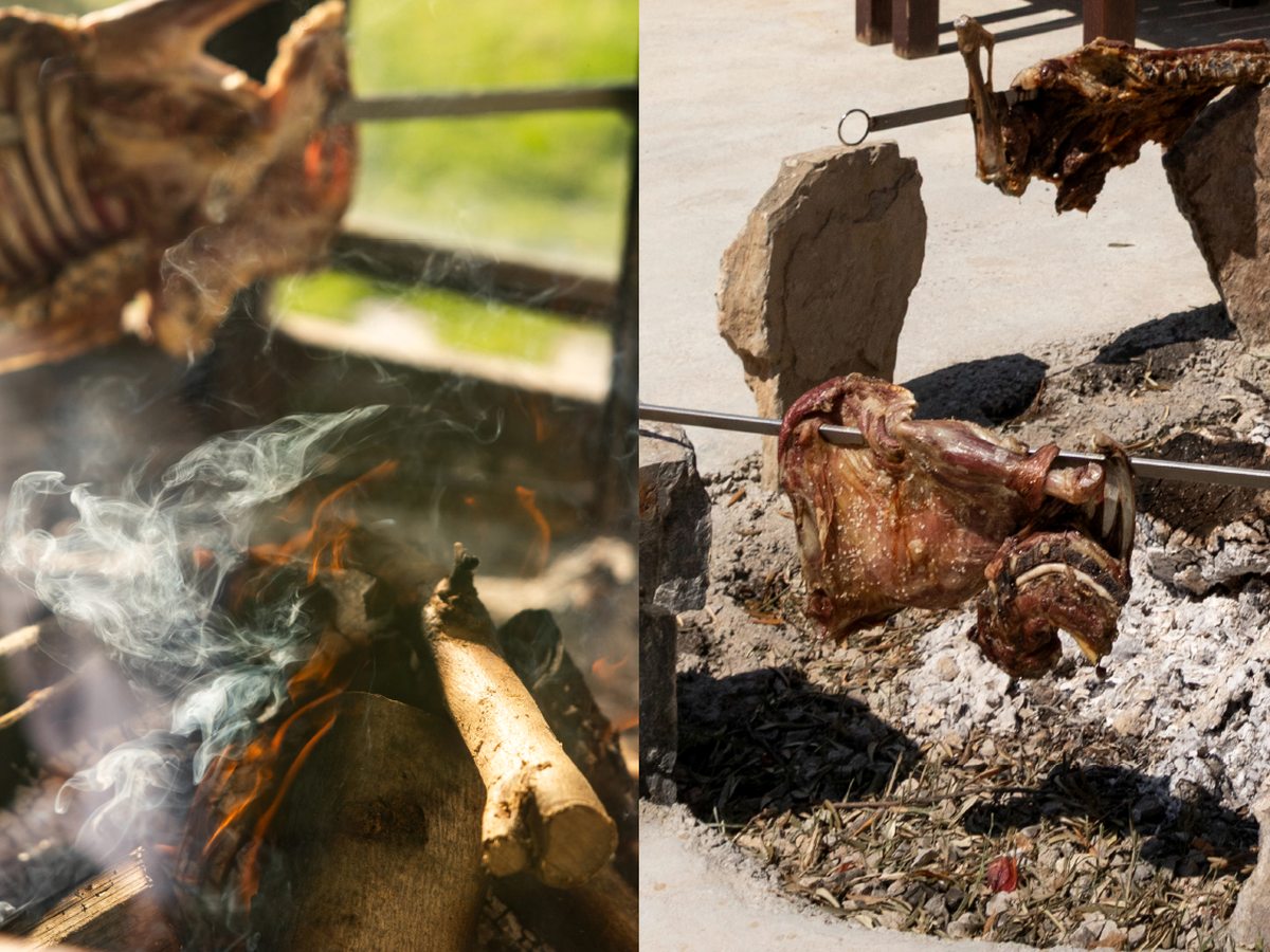Lamb roasting Cretan-style on spits around an open wood fire and embers.