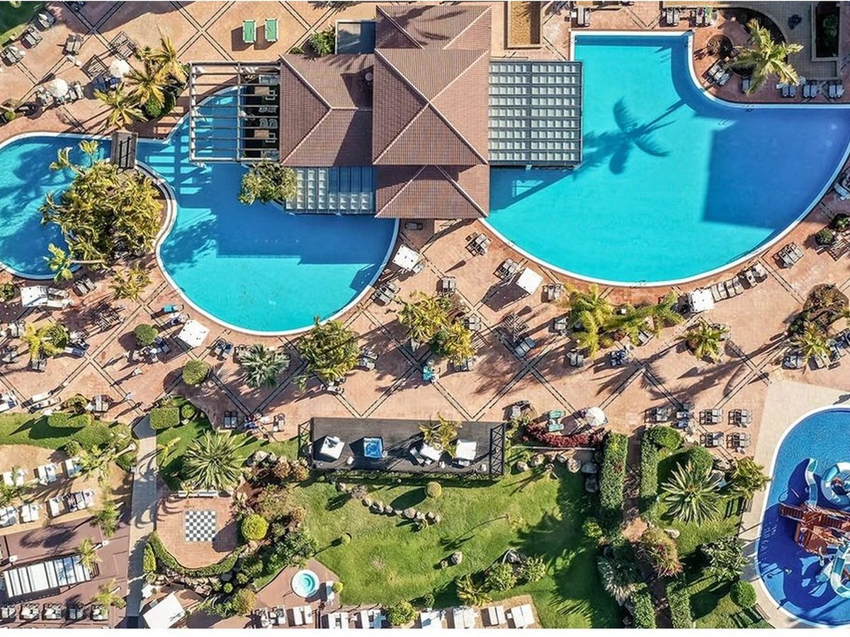 An aerial view down onto the resort's cluster of pools, paved terraces and the Jungle Park water park.