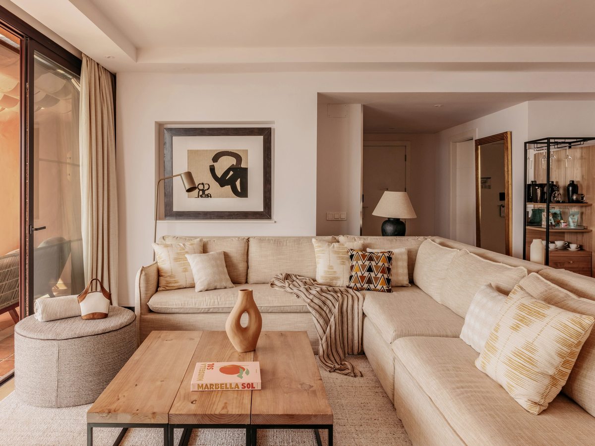 A separate suite living room with cream sofas, a coffee table and sliding doors to a terrace.