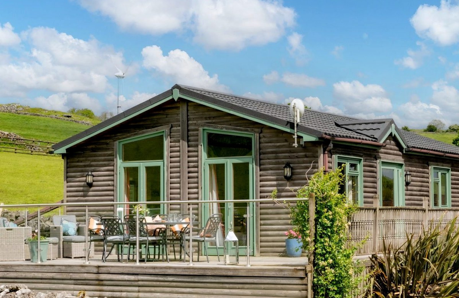 Hoe Grange Holidays, a working hill farm in the Derbyshire Peak District, with log cabins among grazed fields and dry-stone walls.