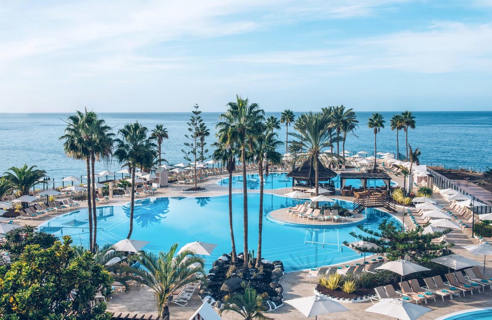 Iberostar Selection Anthelia: a five-star resort in gardens on Fañabé beach in Costa Adeje, with pools and palms above the pale sand and the Atlantic beyond.