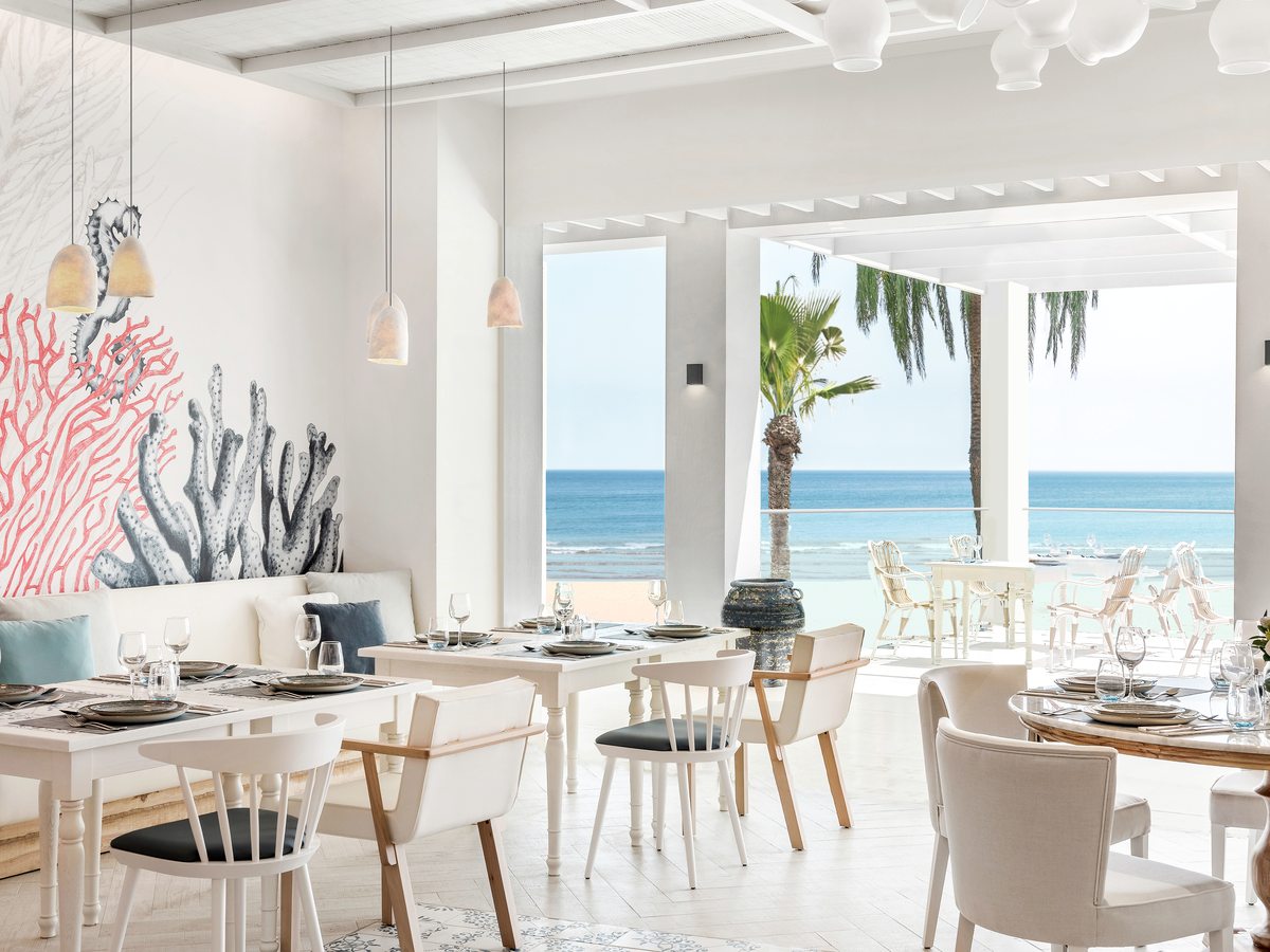 Ouzo, the Greek restaurant at Ikos Andalusia, blue and white dining room opening towards the beach.