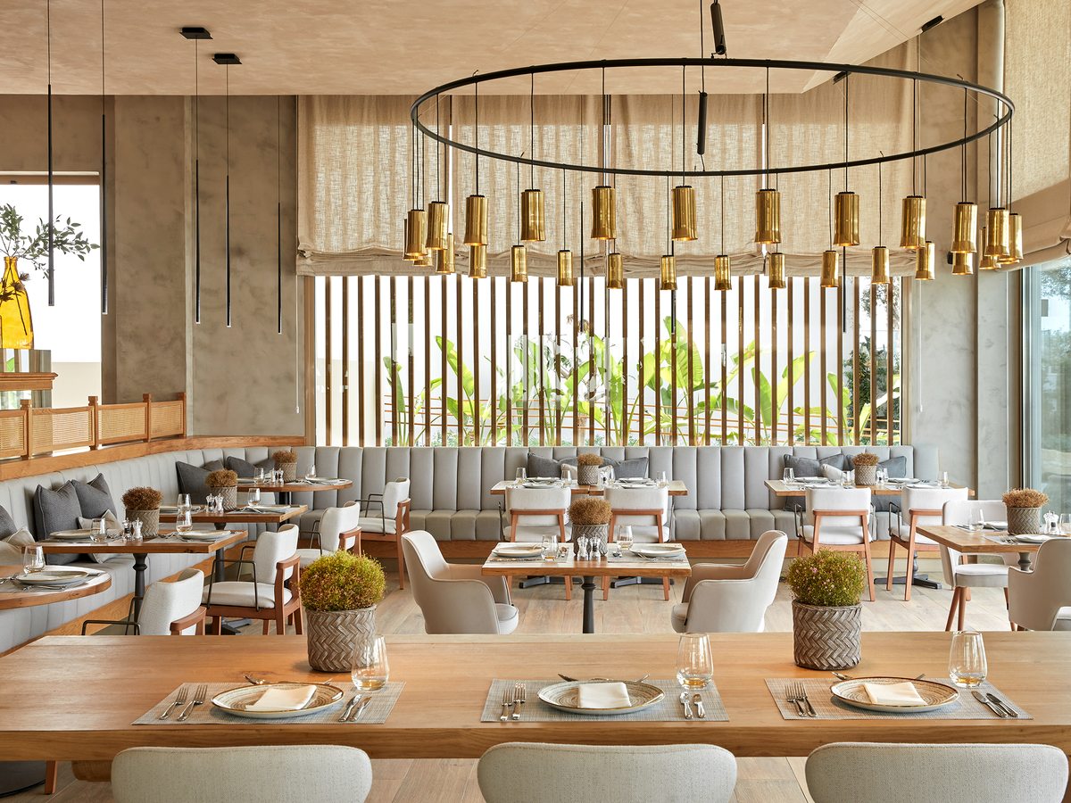 Fresco, the Italian restaurant at Ikos Andalusia, set tables and banquette seating in a bright dining room.