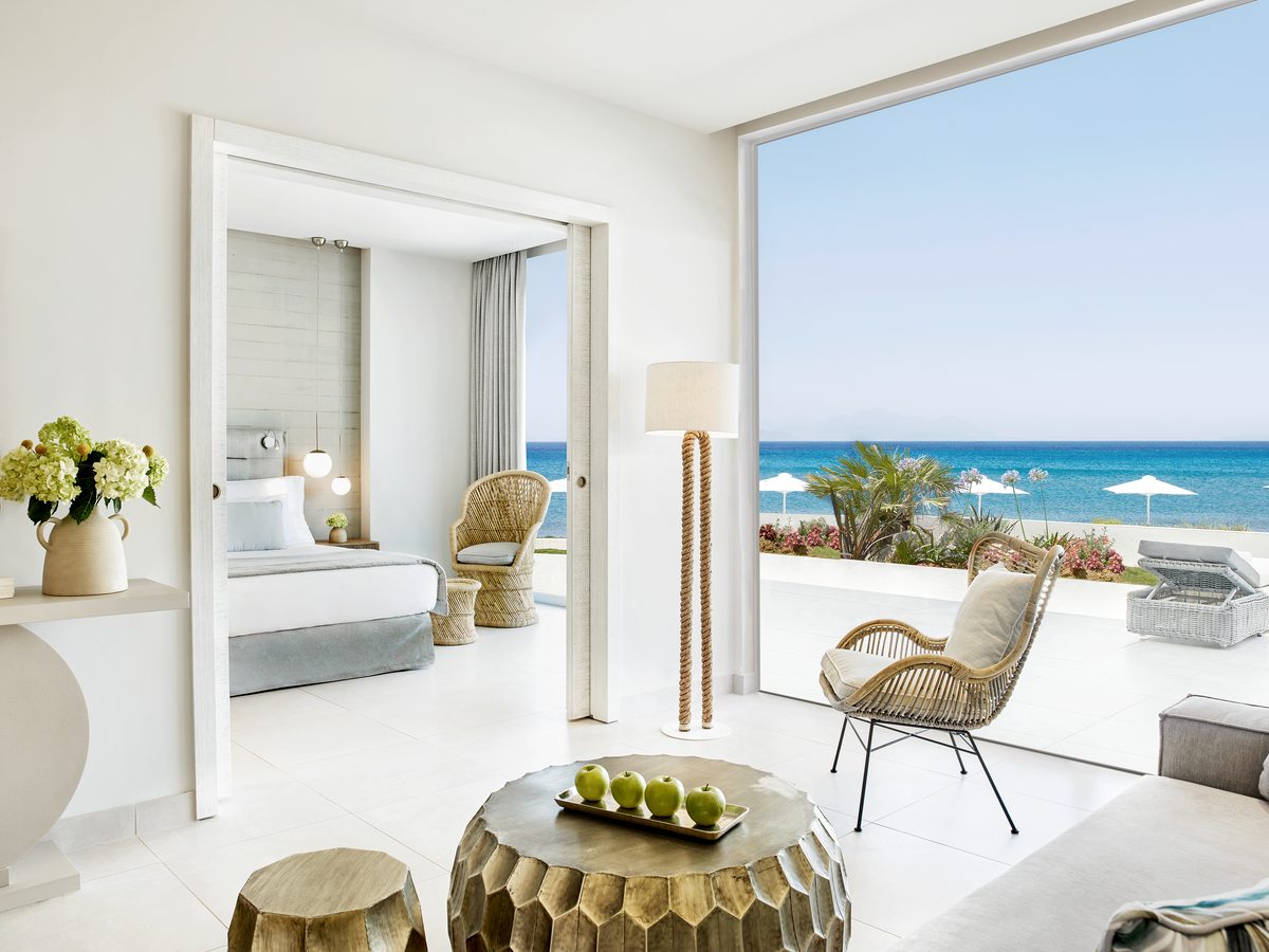 A One Bedroom Suite with the bedroom set behind a partition, a separate seating area and doors out to a private garden.