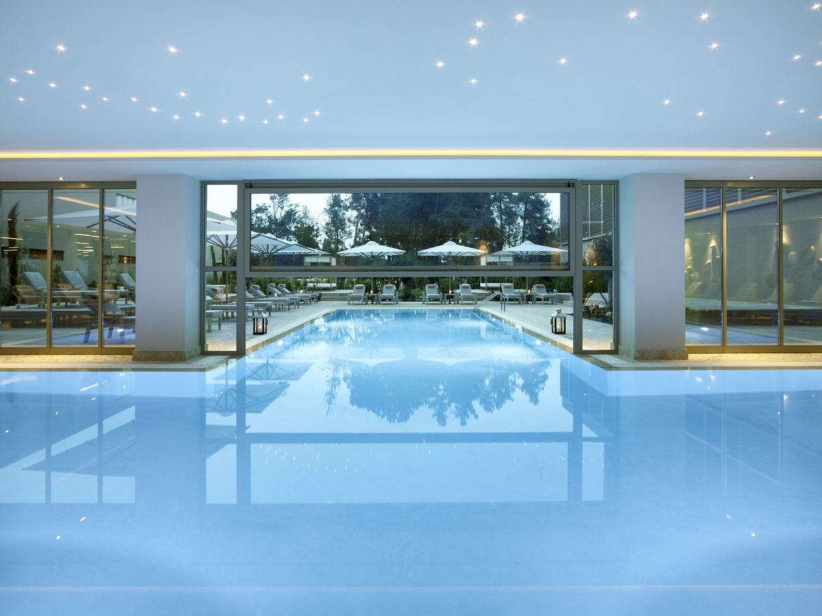 Indoor pool with a glass wall onto the gardens and pinpoint lights set into the ceiling.